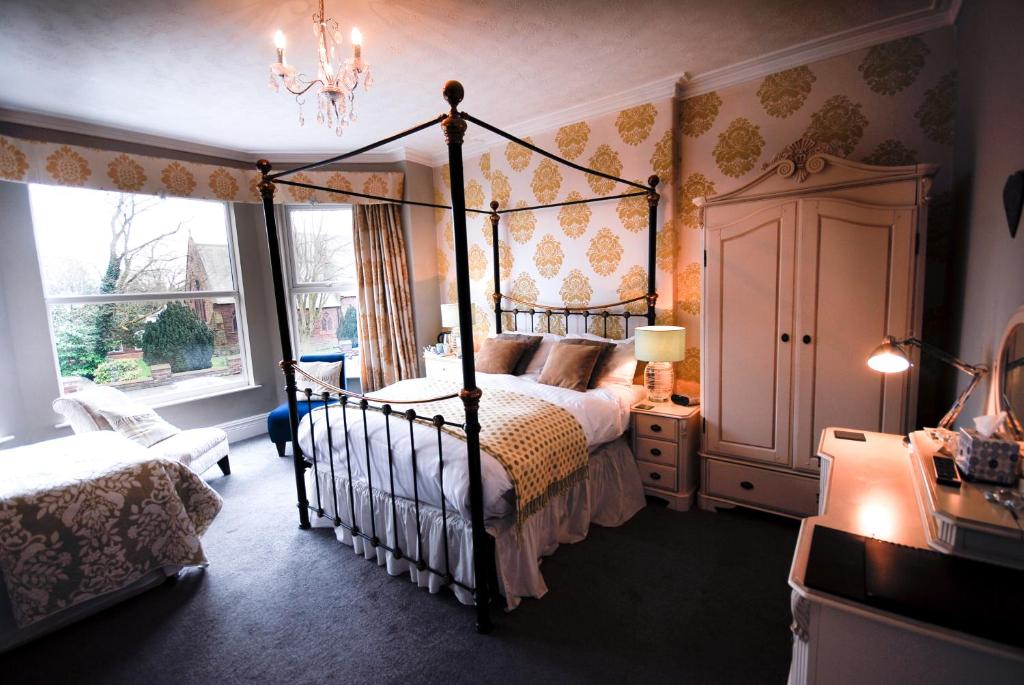 1 dormitorio con cama con dosel y ventana en Kilmorey Lodge, en Chester
