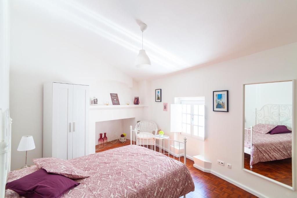 ein Schlafzimmer mit einem Bett und einem großen Spiegel in der Unterkunft Poet's house in historic center in Évora