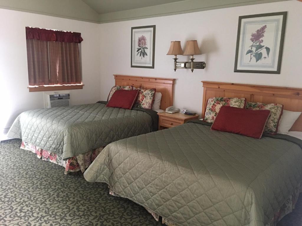 a bedroom with two beds and two lamps at River's Edge Resort in Fairbanks
