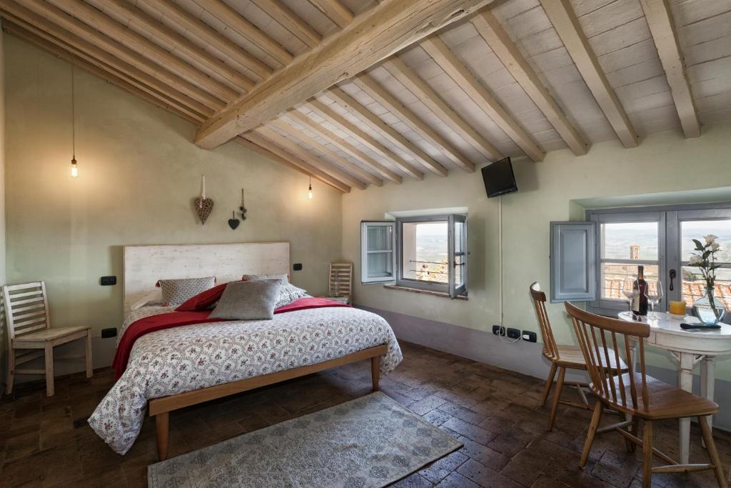 um quarto com uma cama, uma mesa e cadeiras em Scalette di Piazza B&B em Montalcino