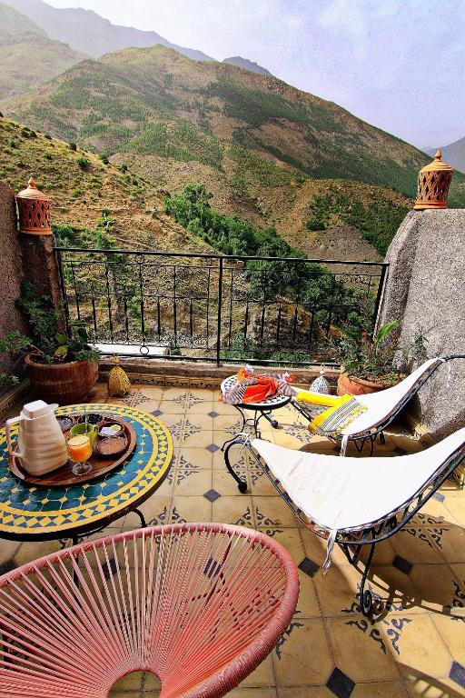 a patio with chairs and a table with a view at Toubkal Garden in Imlil