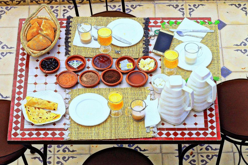 a table with plates and bowls of food and drinks at Toubkal Garden in Imlil