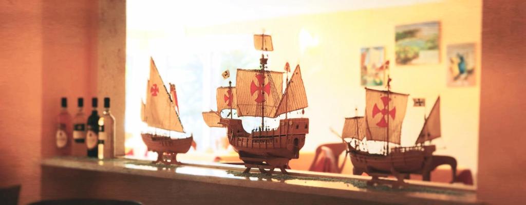 a model ship on a shelf with wine bottles at Hotel Bologna in Bardolino