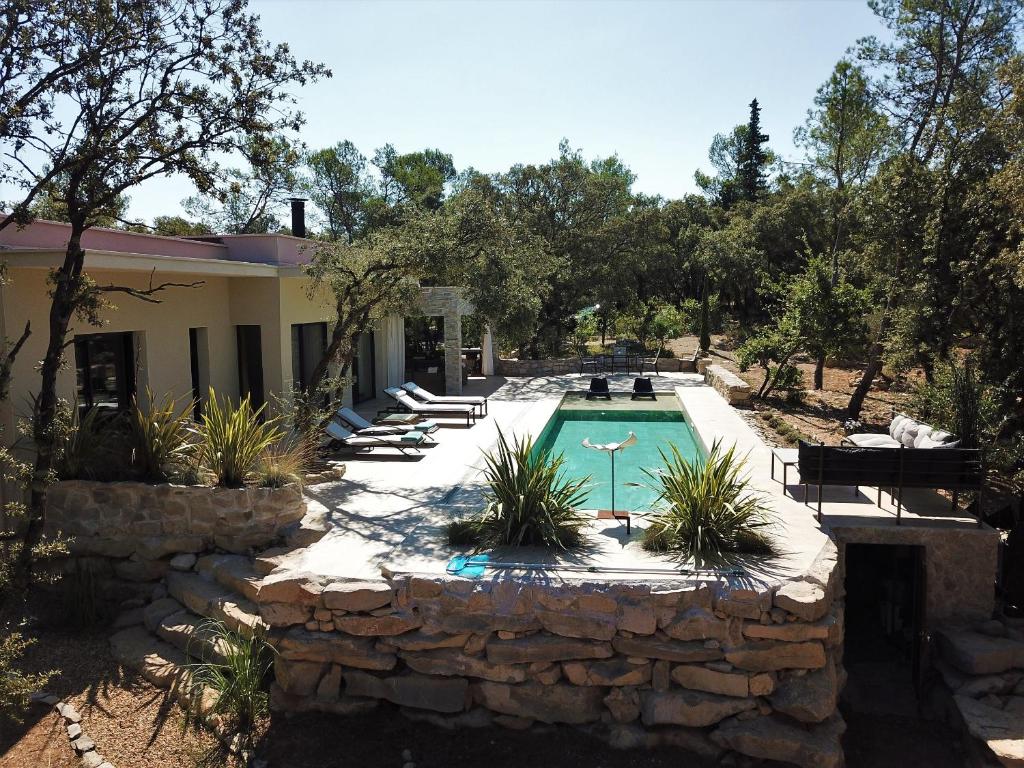 a swimming pool in a yard with chairs and a house at La Villa Kallisté in Vacquières