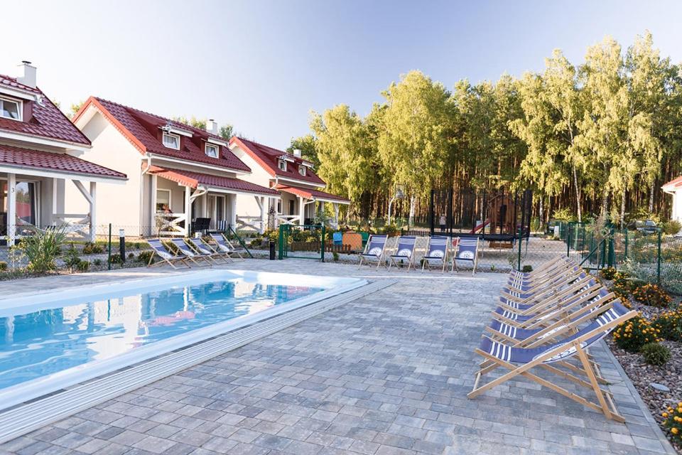 a swimming pool with lounge chairs next to a house at Rodzinna Przystan in Uście