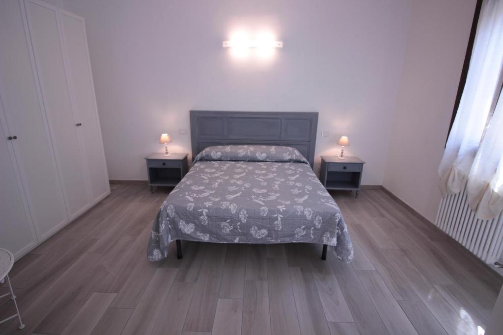 a bedroom with a bed and two night tables with lamps at Alloggio I Grifoni in Ferrara