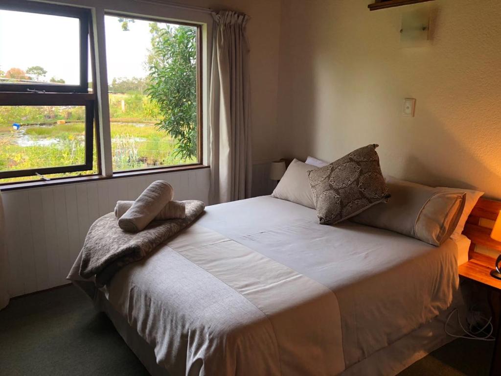 a bedroom with a bed with a large window at Natures Way Farm Cottage in The Crags