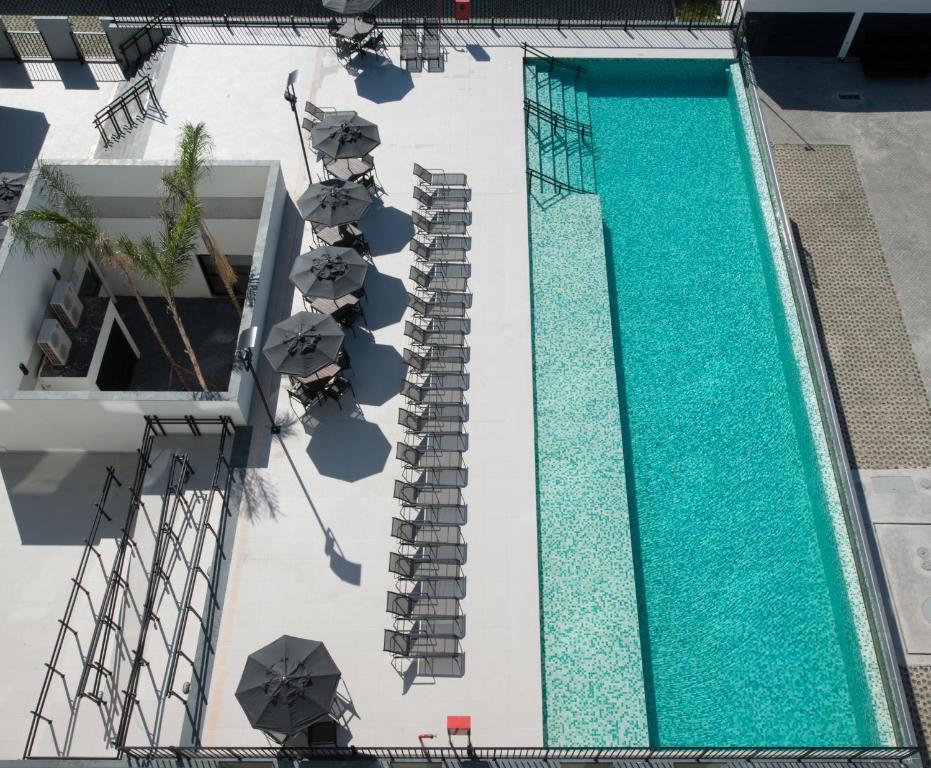an overhead view of a swimming pool with stairs and umbrellas at Linx Galeão in Rio de Janeiro