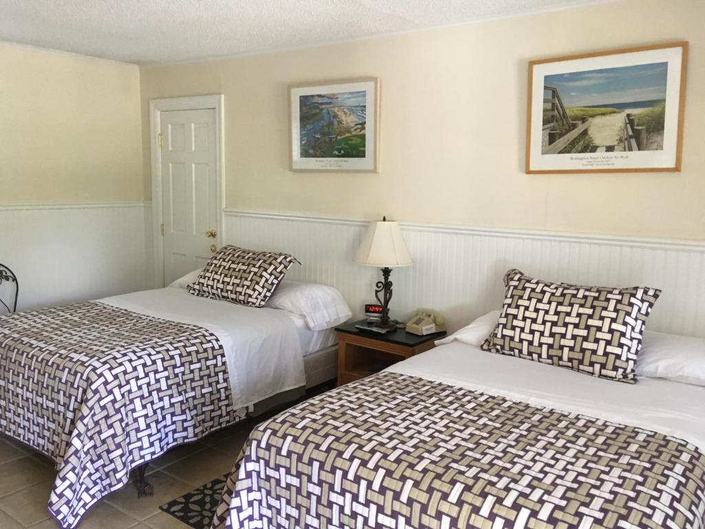 una habitación de hotel con 2 camas y una lámpara en Westhampton Seabreeze Motel, en Westhampton