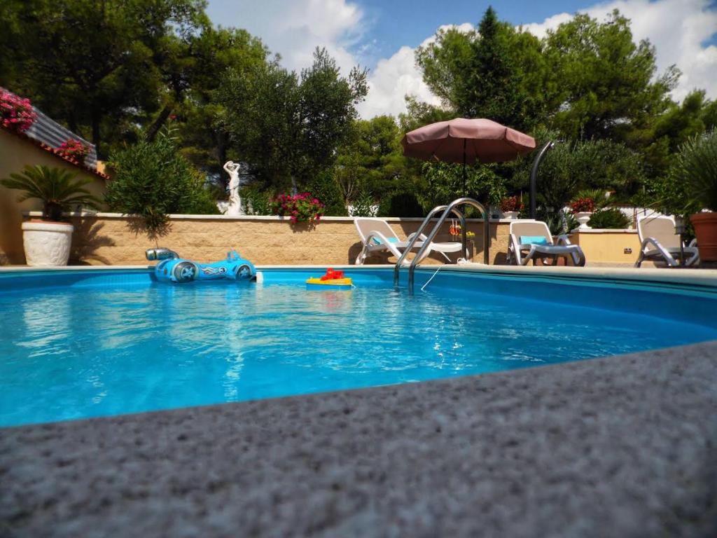 a swimming pool with a blue swimming pool at Holiday Home Villa Romantica in Sveti Filip i Jakov
