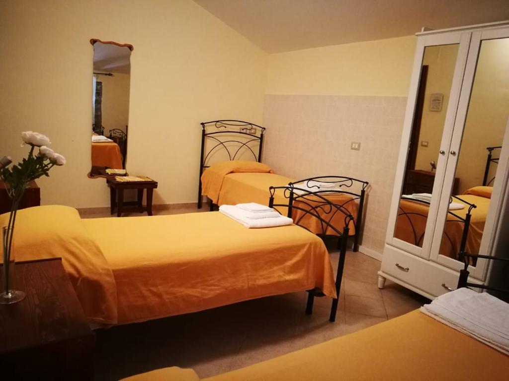Habitación de hotel con 2 camas y espejo en La Rosa Del Barone en Cancellara