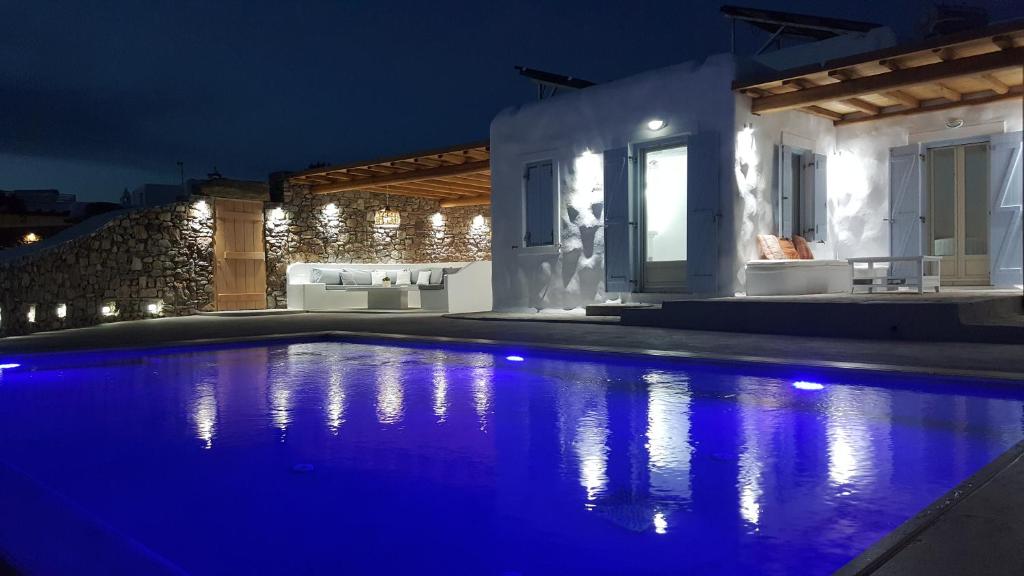 a house with a swimming pool at night at Empress Villa in Platis Yialos Mykonos