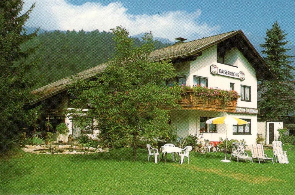 ein Haus mit einem Tisch und Stühlen davor in der Unterkunft Ferienwohnungen Josef & Karin Ketterl in Sachrang