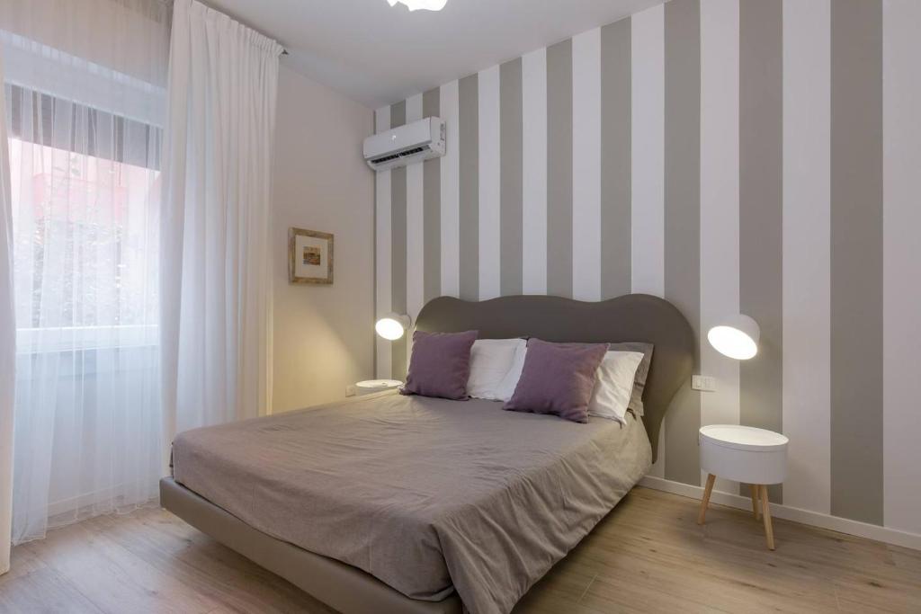 una camera con letto e parete a righe di Verona's Apartment near the Arena a Verona