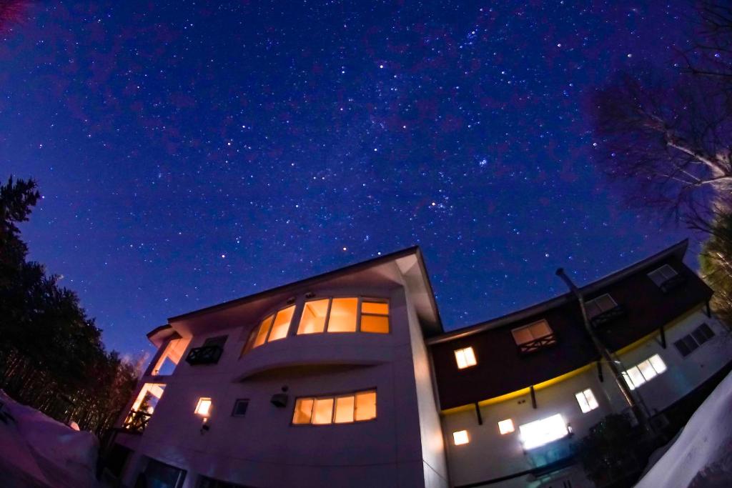 un edificio de noche con un cielo estrellado en Pension Entre - deux - Mers, en Hachimantai
