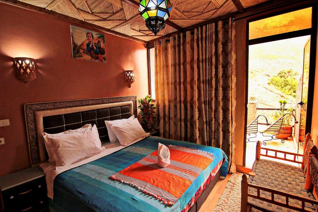 a bedroom with a bed and a large window at Toubkal Garden in Imlil