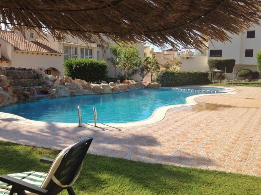 オリフエラ・コスタにあるSuperbe appartement avec piscine (Costa Blanca)の椅子付きの庭のスイミングプール