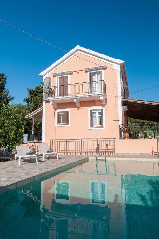 a house with a swimming pool in front of a house at Villa Tettix (Τέττιξ) in Fiskardo