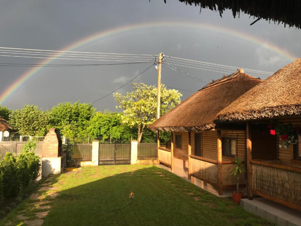 a rainbow in the sky over a house with a yard at Casa Arina in Vişina