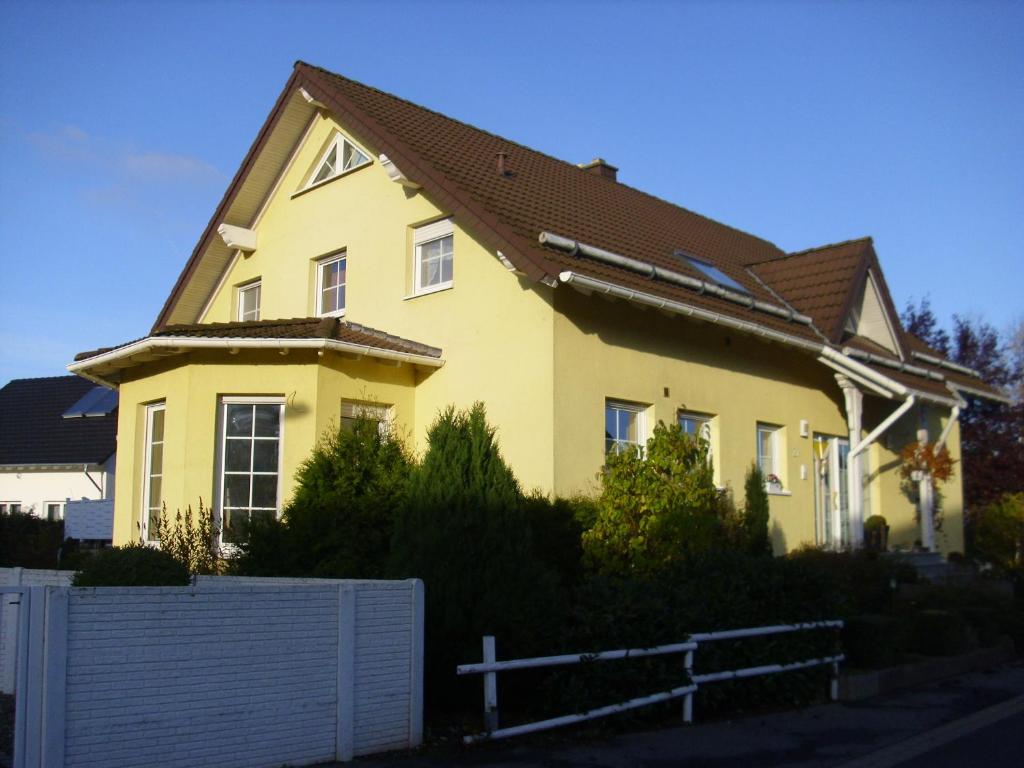 una casa amarilla con techo marrón en Haus Mühlenbach en Mechernich