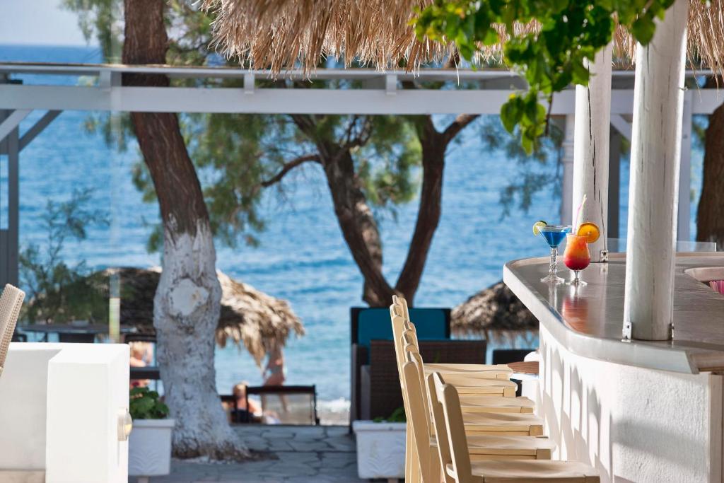 a table and chairs with a view of the ocean at Alesahne Beach Hotel in Kamari