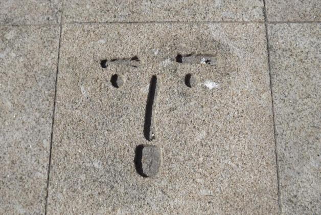 a face drawn on the floor of a sidewalk at Art Gallery Apartment in Porto