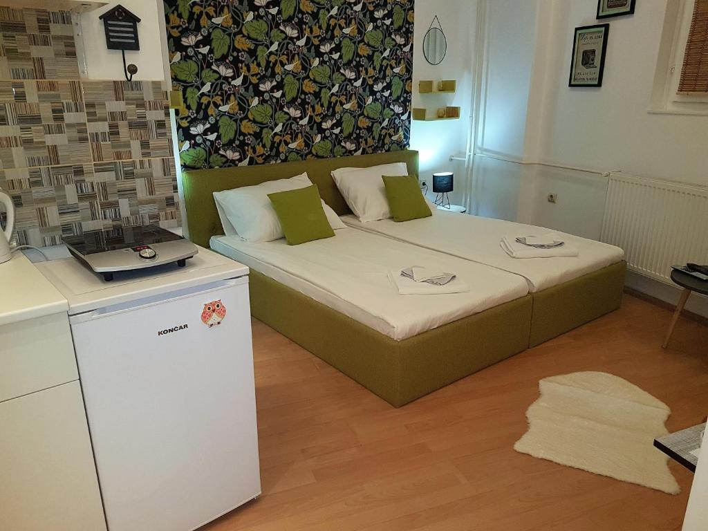 um pequeno quarto com uma cama com um computador portátil em Apartman Centar em Niš