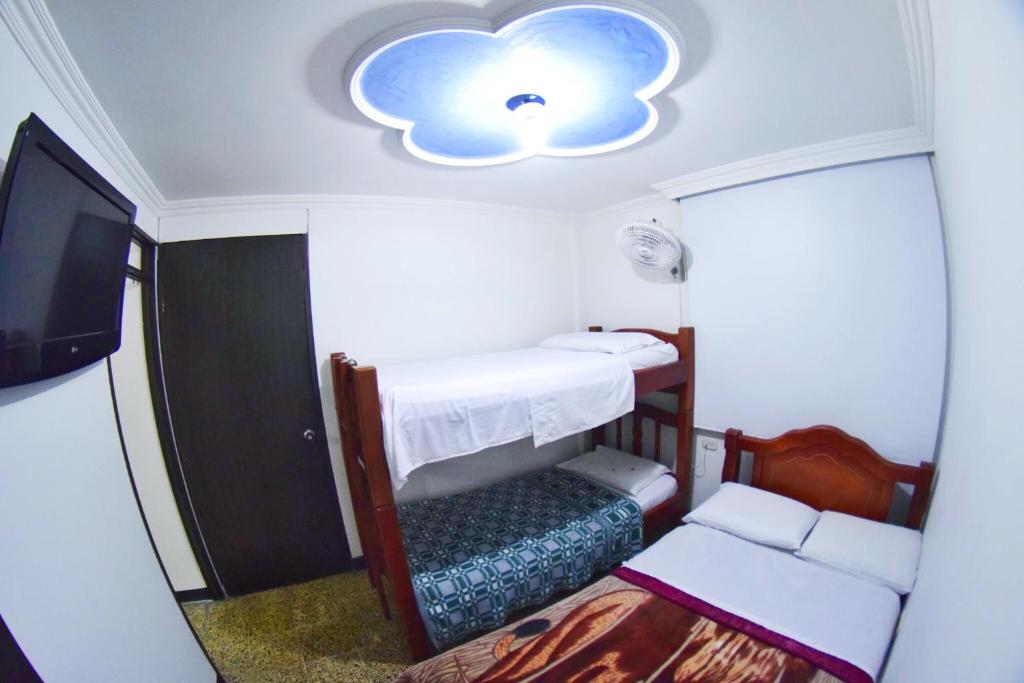 um pequeno quarto com uma cama e um tecto de nuvens em Hotel Los Cristales em Pereira