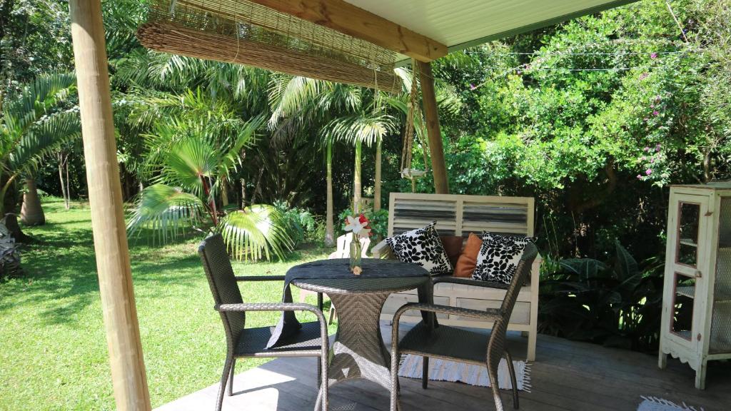 d'une terrasse avec une table et des chaises sous un auvent. dans l'établissement CHAMBRES LEZARD Home, à Païta