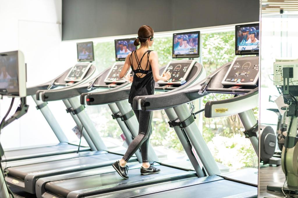 a woman walking on a treadmill in a gym at Cerulean Tower Tokyu Hotel, A Pan Pacific Partner Hotel in Tokyo