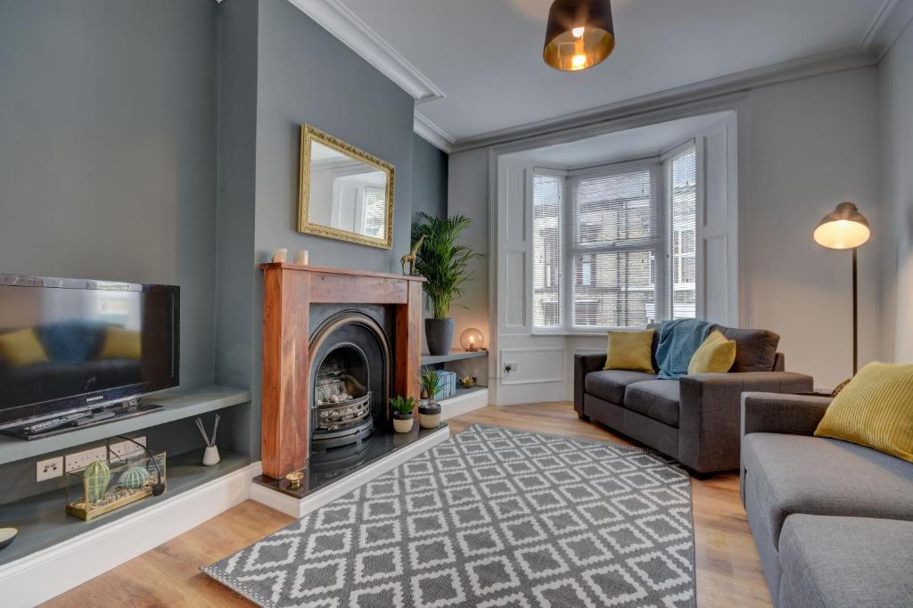 a living room with a fireplace and a tv at 38 George Street in Whitby
