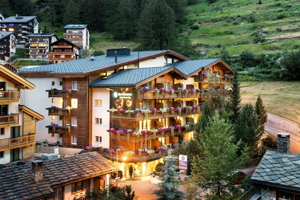 a hotel in the middle of a town with buildings at Hotel Butterfly, BW Signature Collection in Zermatt