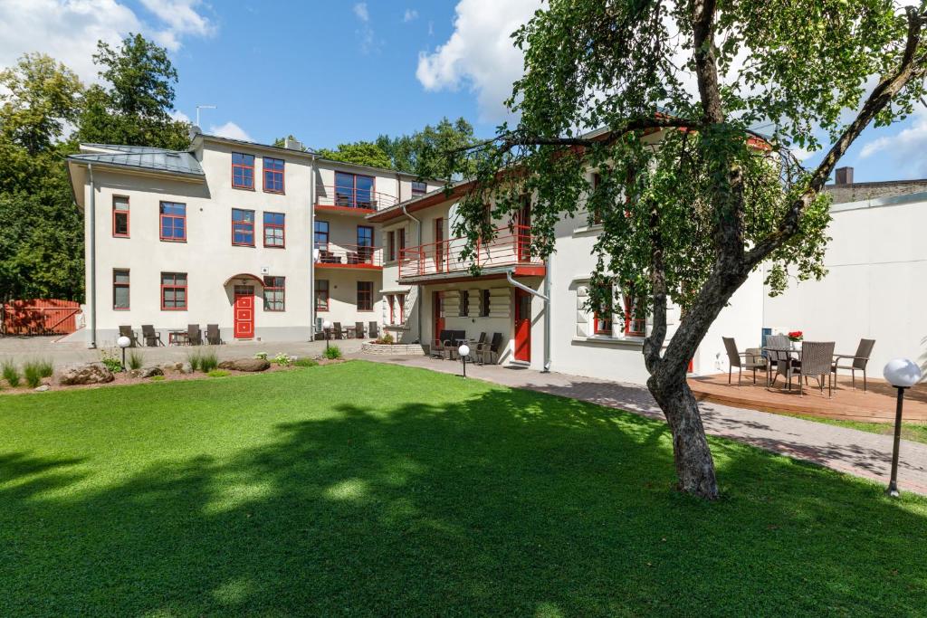 un grande edificio bianco con un albero nel cortile di Vabaduse Apartments a Pärnu