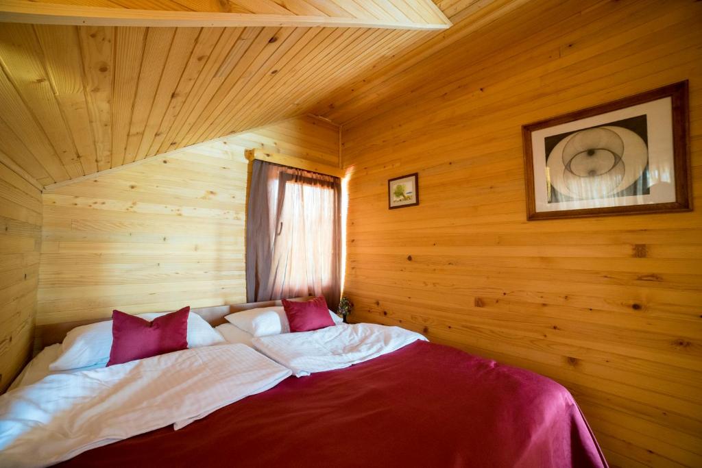a bedroom with a bed in a wooden room at Holiday homes Piralo in Kostajnica