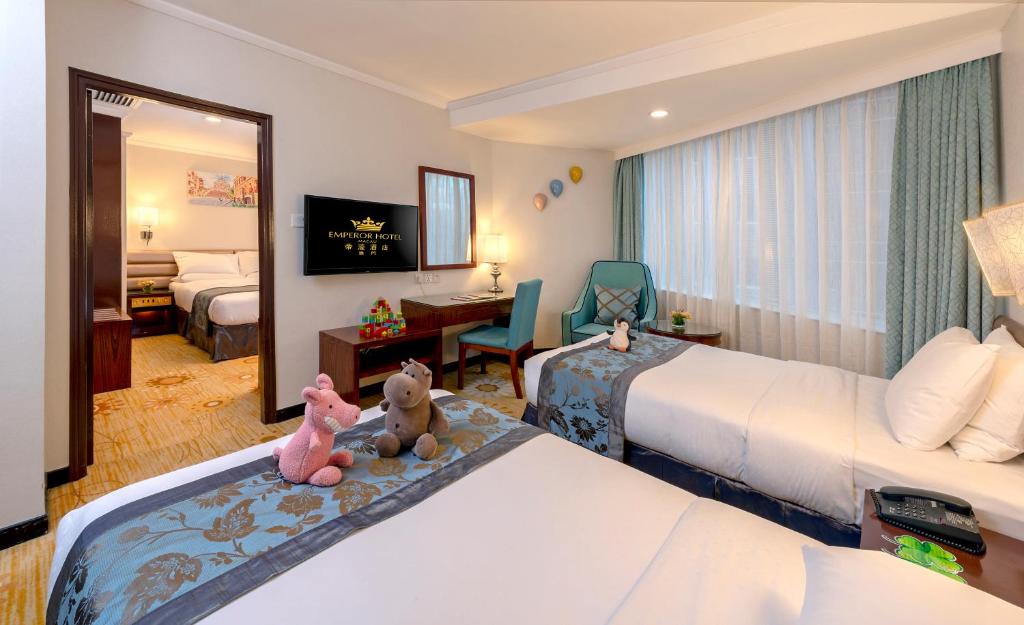 Postel nebo postele na pokoji v ubytování Emperor Hotel