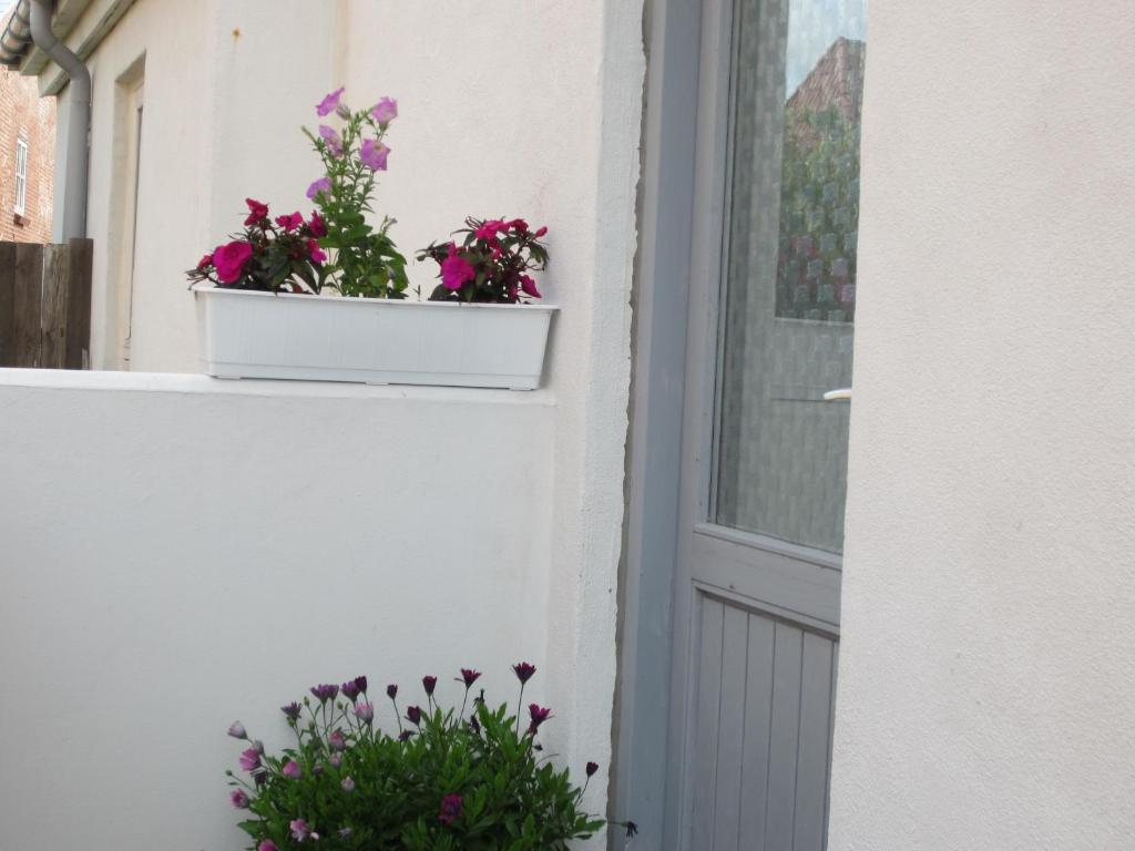 un fioraio bianco su un davanzale con fiori di Jernbanegade 13.1 a Thyborøn