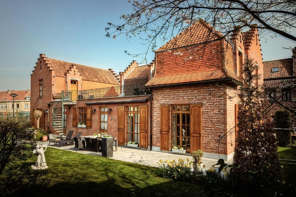 a large brick building with windows and a yard at B&B Ter Vesten in Ieper