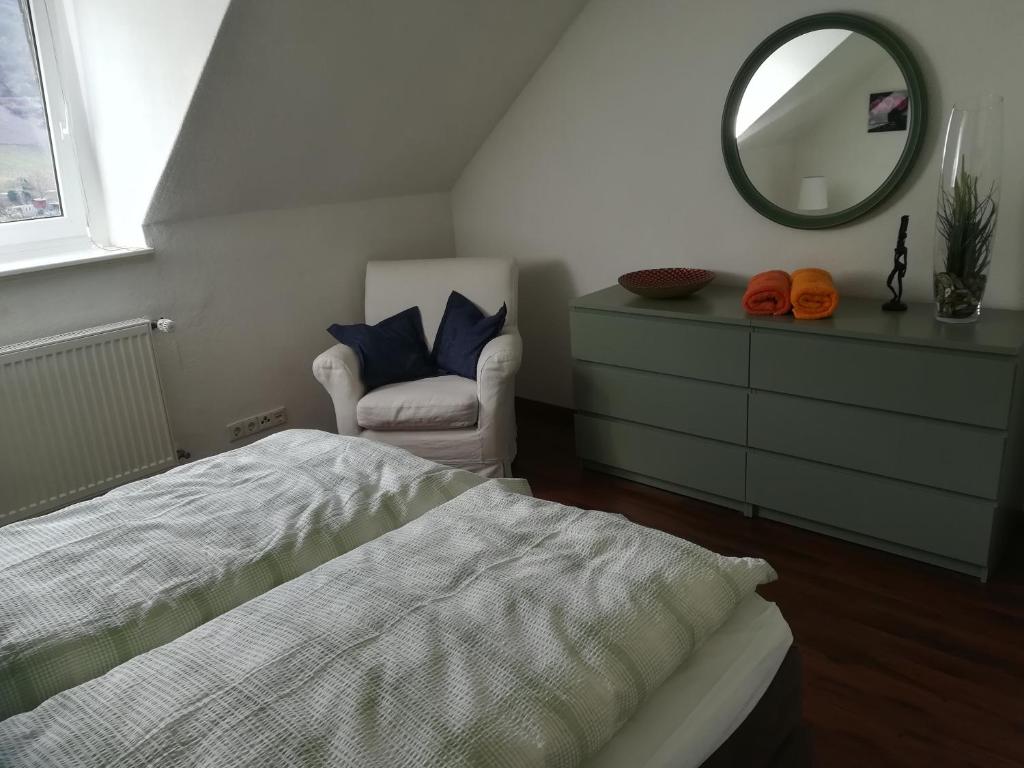 - une chambre avec un lit, un miroir et une chaise dans l'établissement Mosel Dream, à Cochem