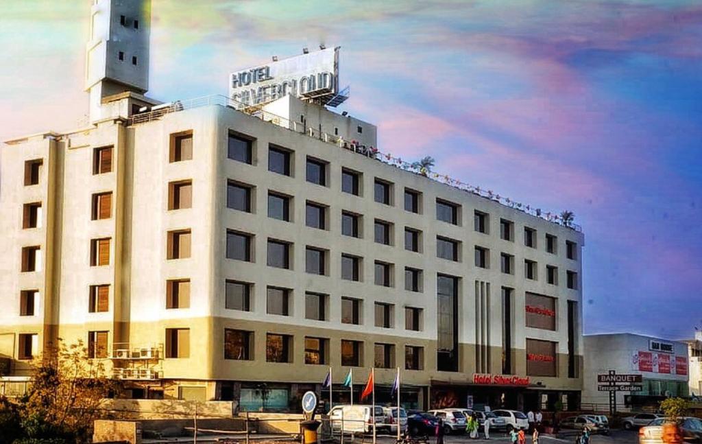um edifício branco com uma placa no topo em SilverCloud Hotel and Banquets em Ahmedabad