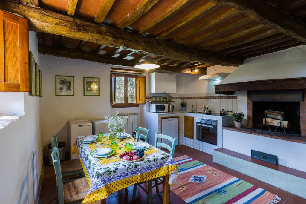 een keuken met een tafel en een keuken met een open haard bij Podere Ianni in San Casciano in Val di Pesa