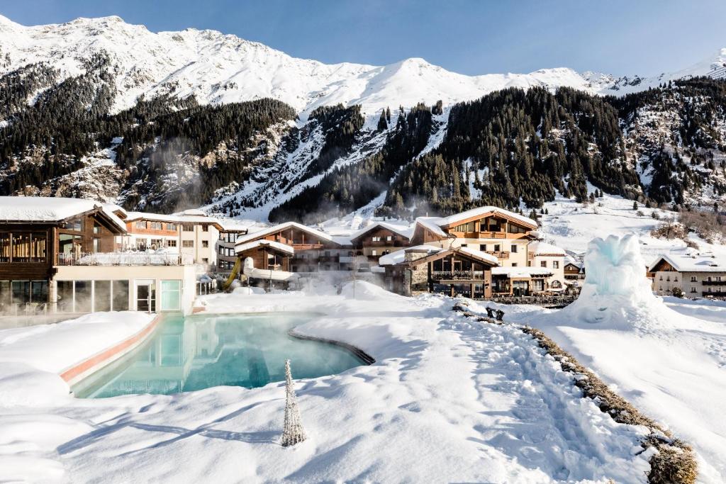 un complexe dans la neige avec une piscine dans l'établissement Hotel Schneeberg Family Resort & SPA, à Ridanna