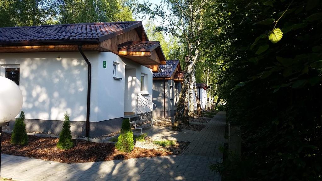 um pequeno edifício branco com um caminho que o conduz em Camping Marina em Sulęcin