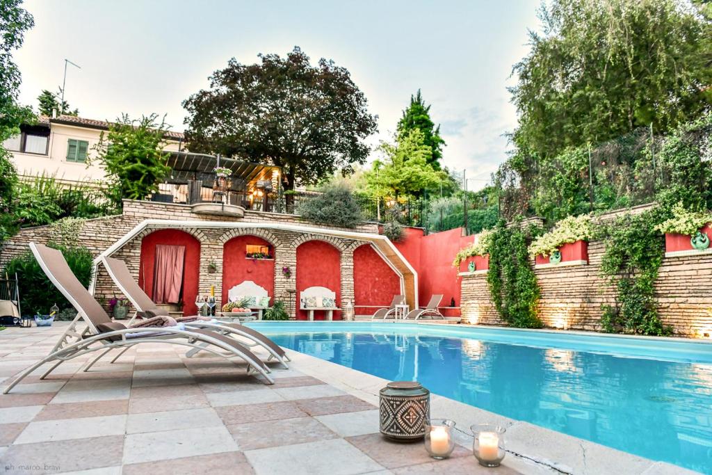 a swimming pool with a chair next to a building at Villa Isidoro ampio parco piscina privata in Verona