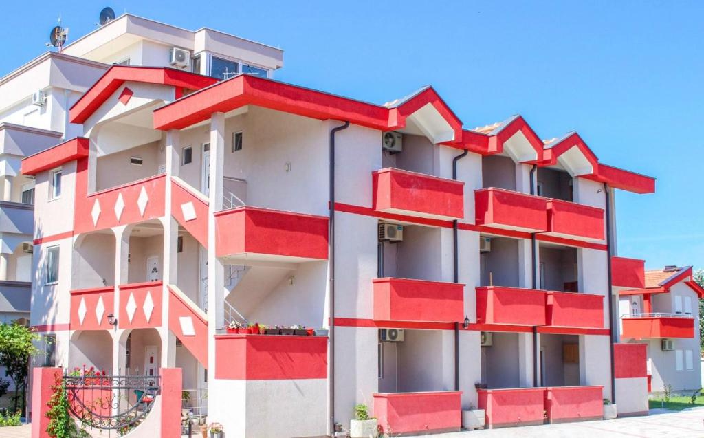 a red and white building with red balconies at Friendly House in Ulcinj