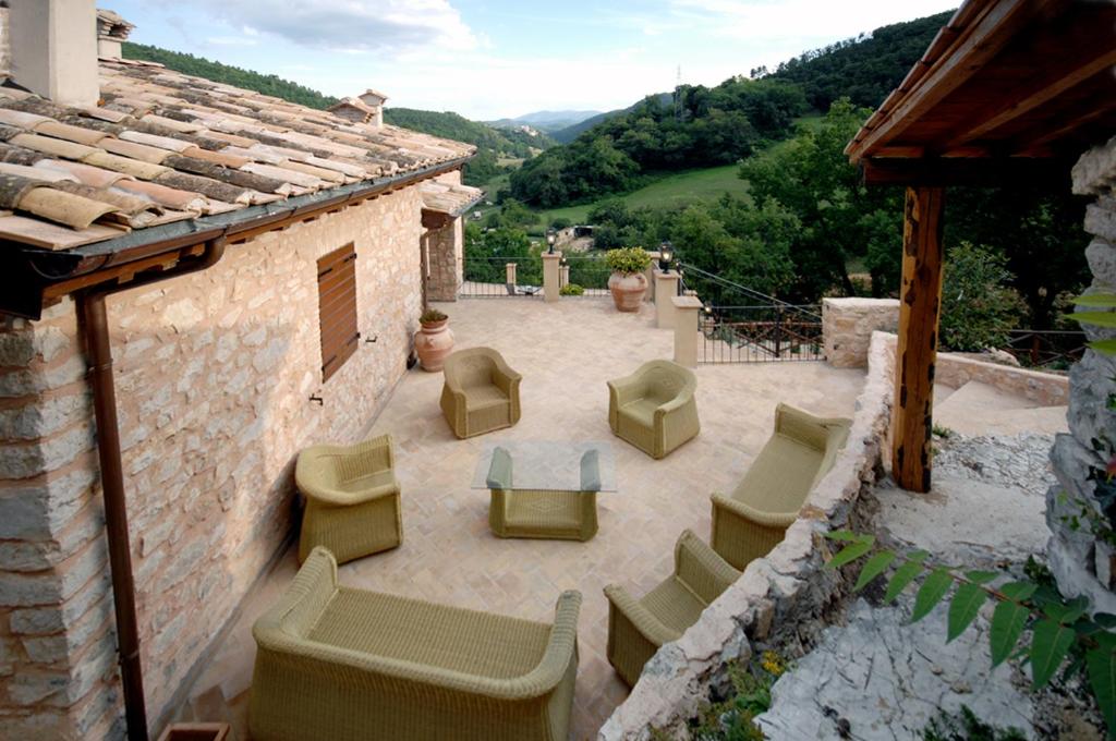 - une terrasse avec des chaises et des tables au-dessus d'un bâtiment dans l'établissement Palazzo Del Papa Agriturismo, à Strettura