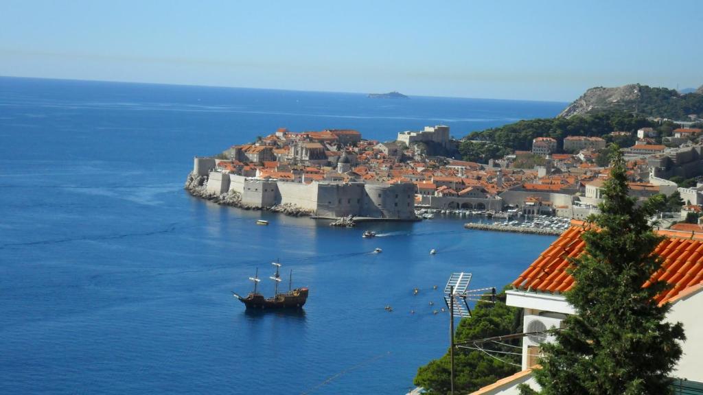 a boat in a body of water next to a city at Apartment Golden View in Dubrovnik