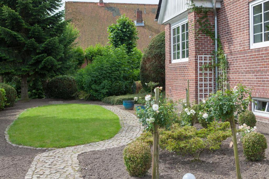 a garden in front of a brick house at FEWO Maisonettenwohnung in Steinkirchen