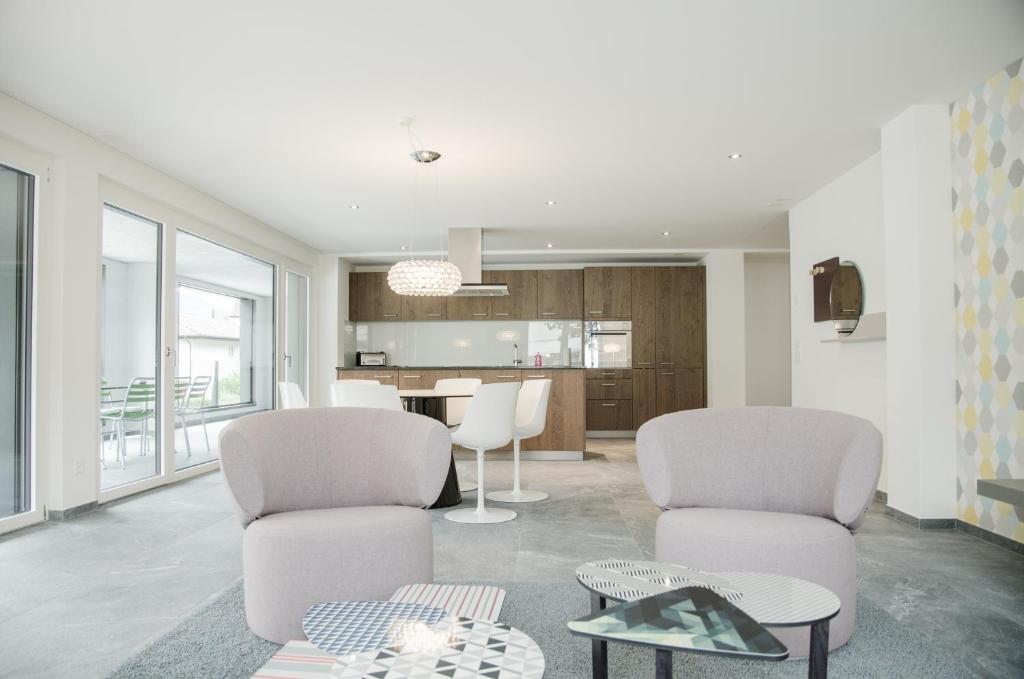 a living room with two chairs and a table at Apartment JungfrauCenter Brienzersee - GriwaRent AG in Interlaken