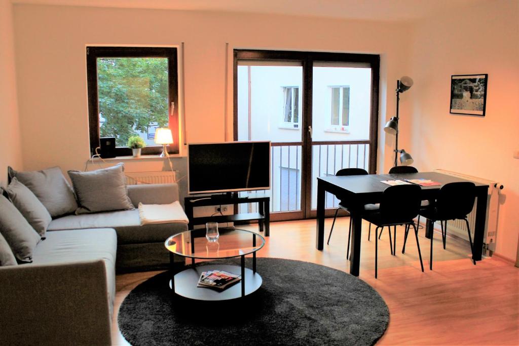 ヴュルツブルクにあるModernes Apartment im Herzen von Würzburgのリビングルーム(ソファ、テーブル付)