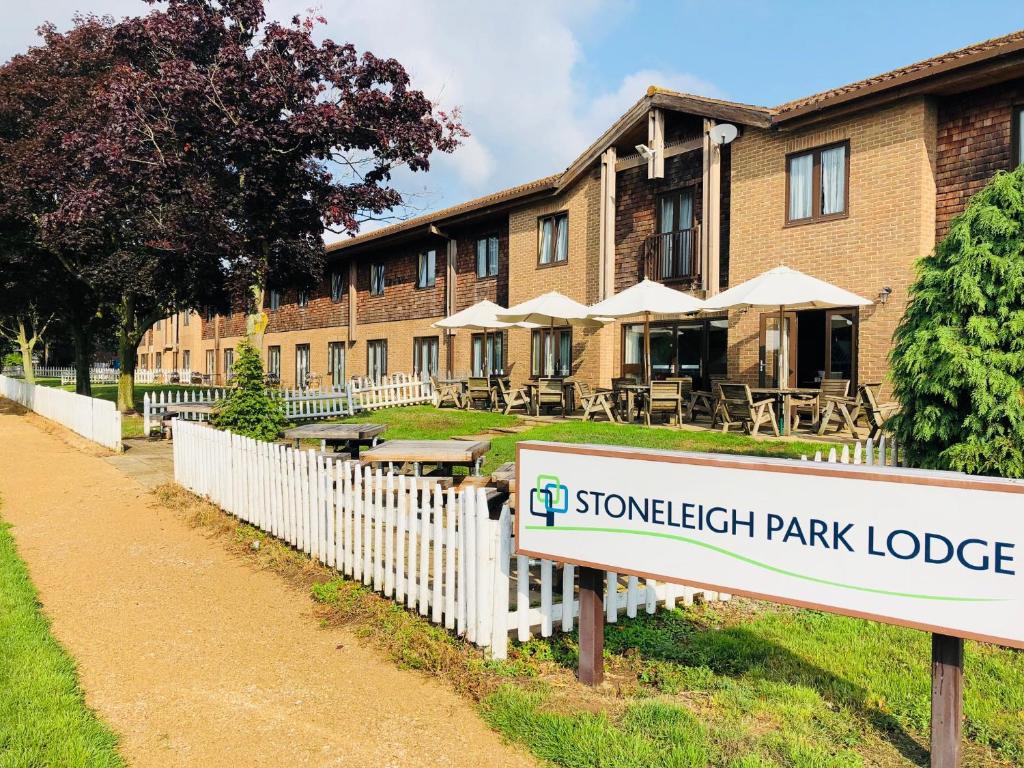 una señal frente a un edificio con un lodge en el parque en Stoneleigh Park Lodge, en Leamington Spa